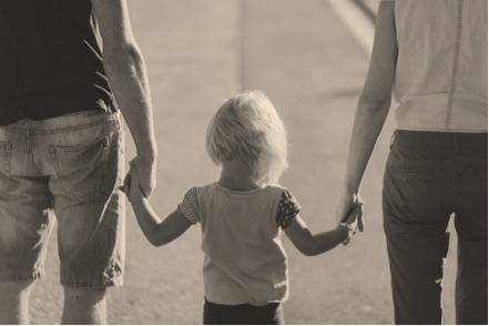 Parents holding a child's hands